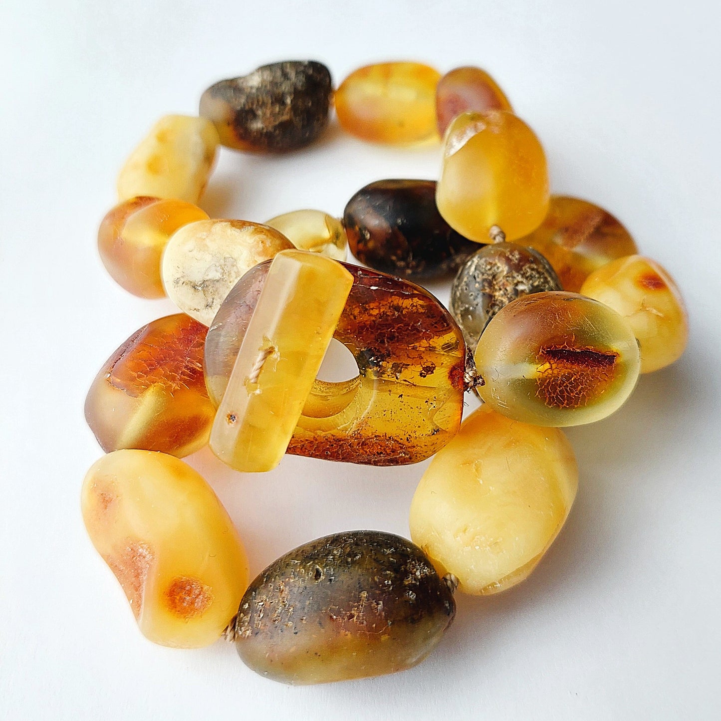 Beaded bracelet with amber and brown stones on a white background