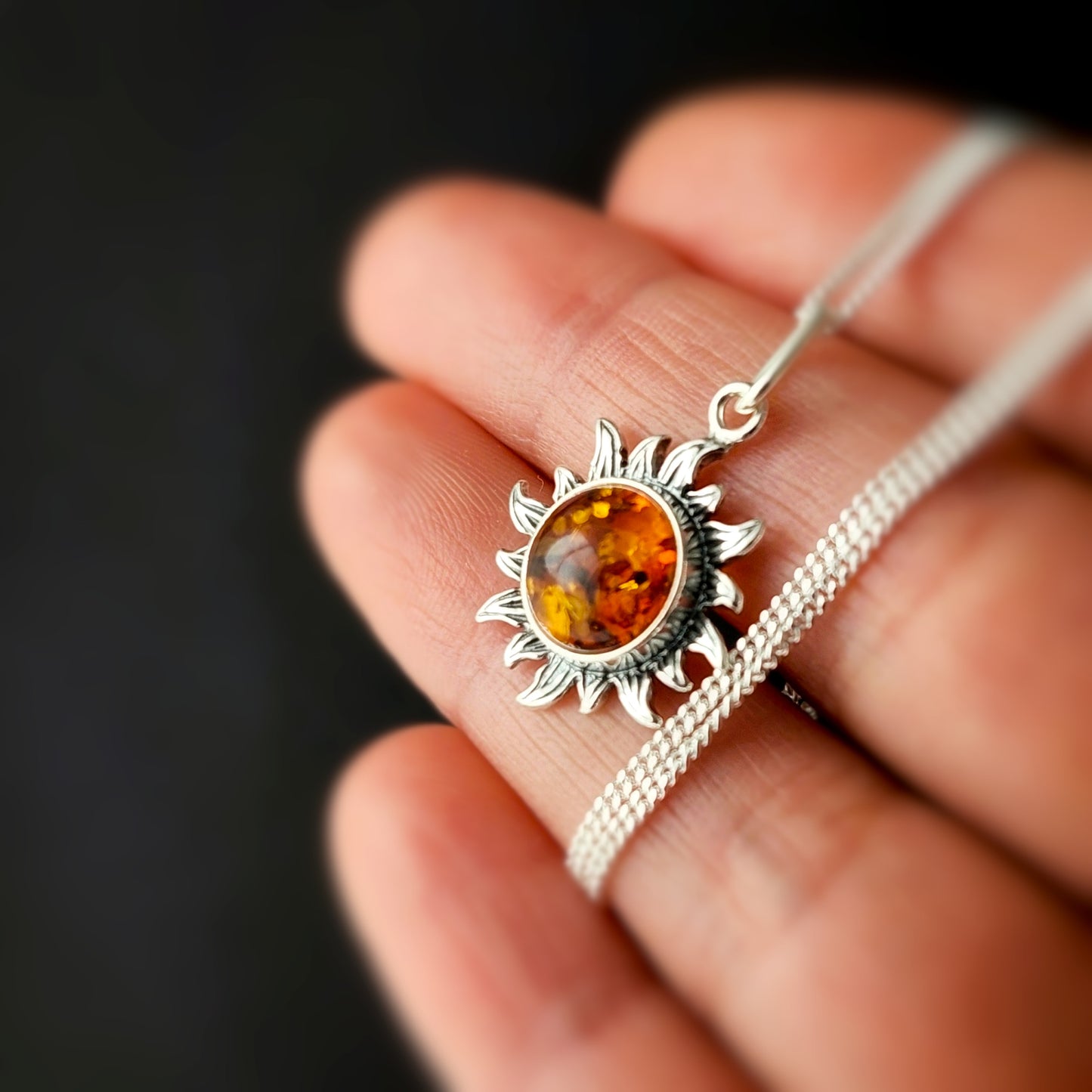 Sterling silver sun-shaped pendant with cognac Baltic amber gemstone on a silver chain, handmade natural amber jewelry.