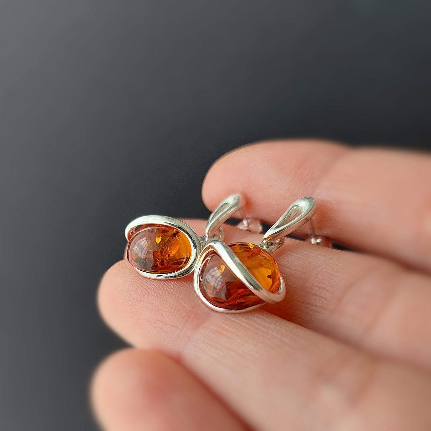Natural Baltic amber earrings in warm honey tone with silver swirl design