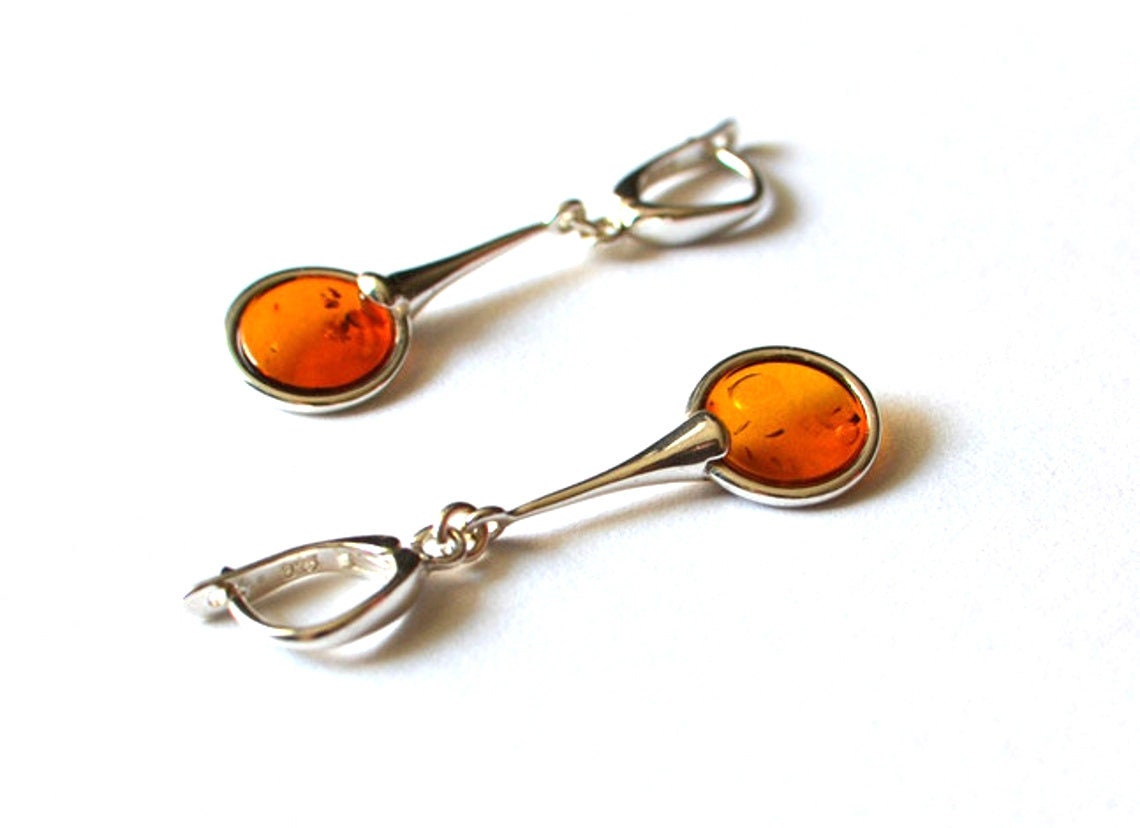 Long sterling silver dangle earrings with round cognac Baltic amber – modern minimalist jewelry handmade in Poland