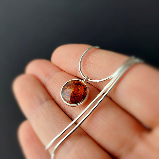 Minimalist silver necklace with round cognac Baltic amber pendant, delicate dainty design on fine chain, handmade jewelry.