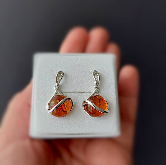 Natural Baltic amber earrings in warm honey tone with silver swirl design